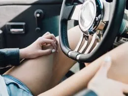 Close up of woman wearing shorts in the driver seat of a truck.